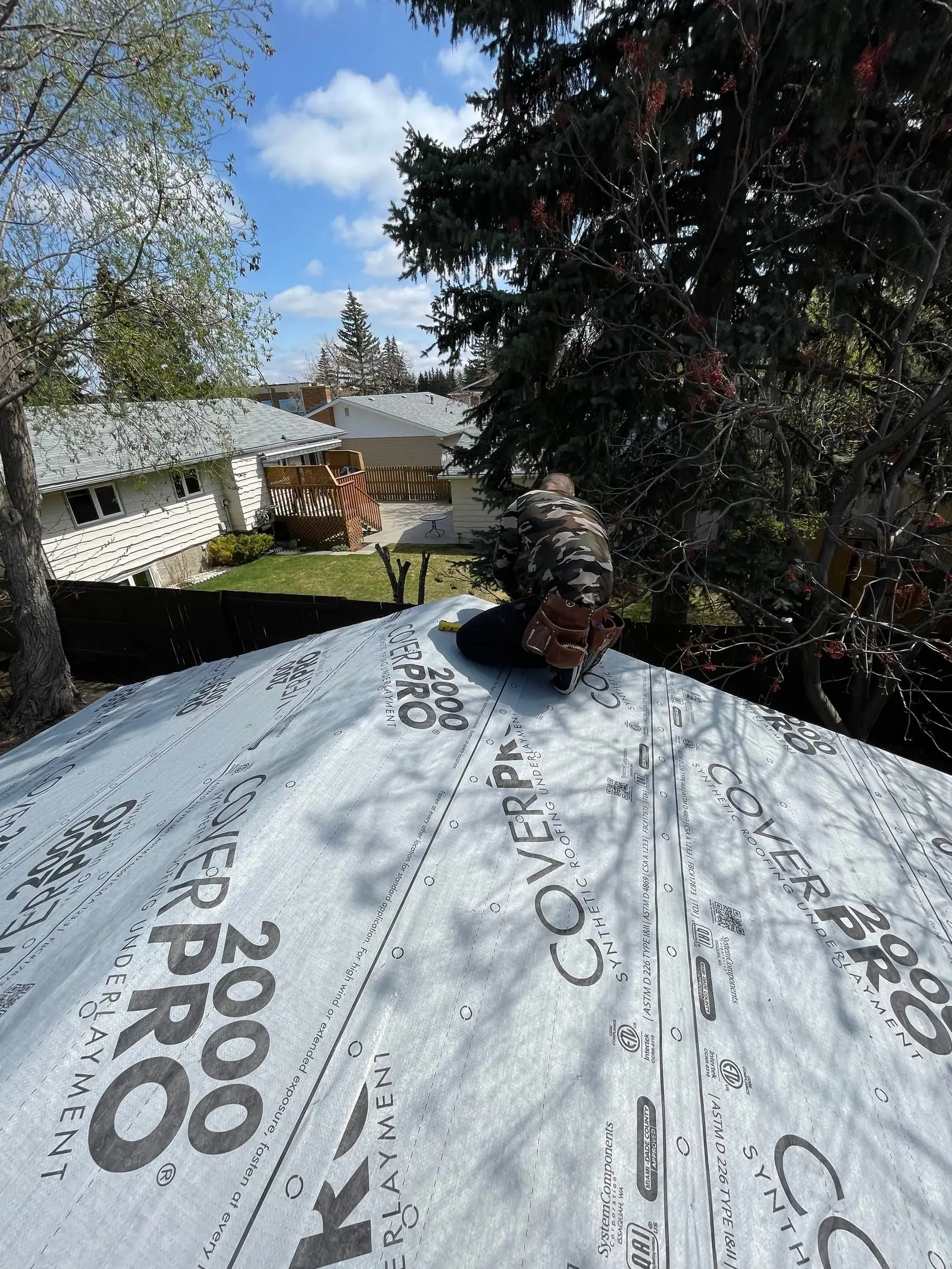 Calgary Roof Repair Ltd roofer laying underlayment on a residential roof deck